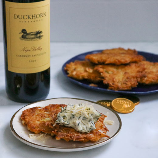 Latkes topped with Spinach Artichoke Dip